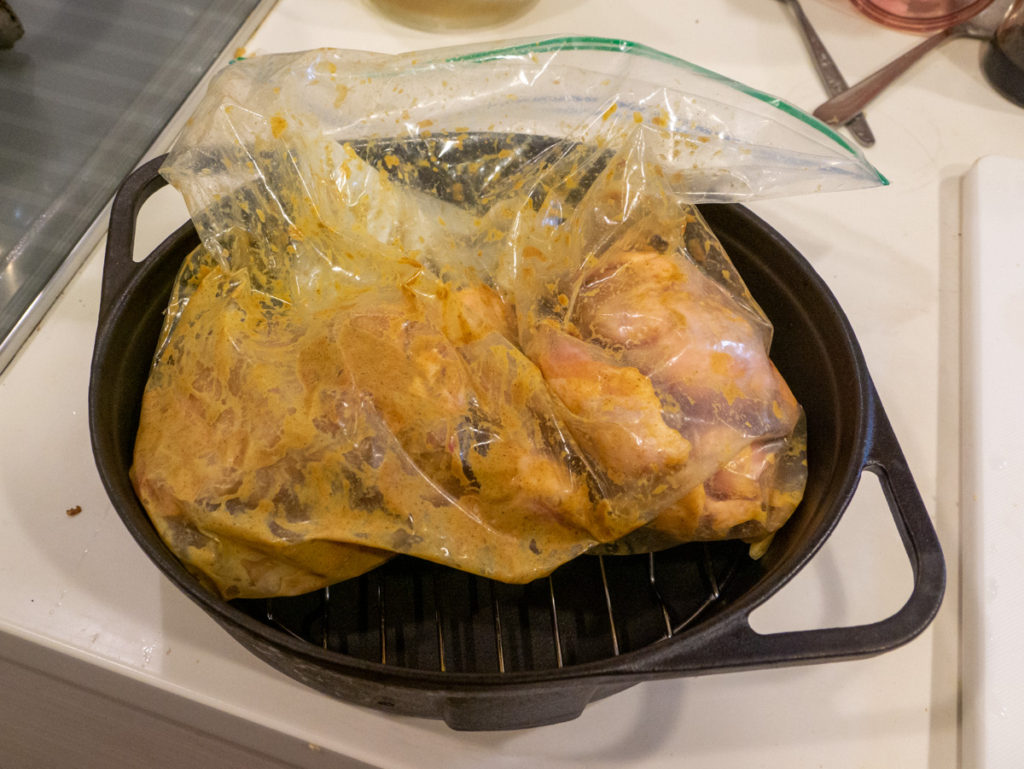 ダッチオーブンにつけ込む鶏肉を入れてサイズを見ているところ
